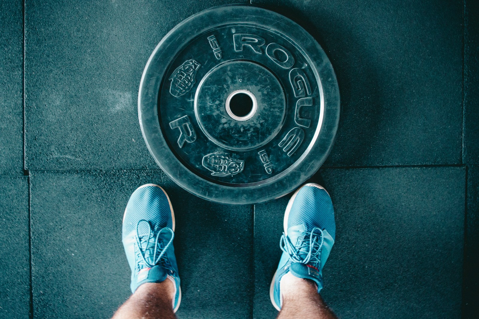 person standing beside black weights